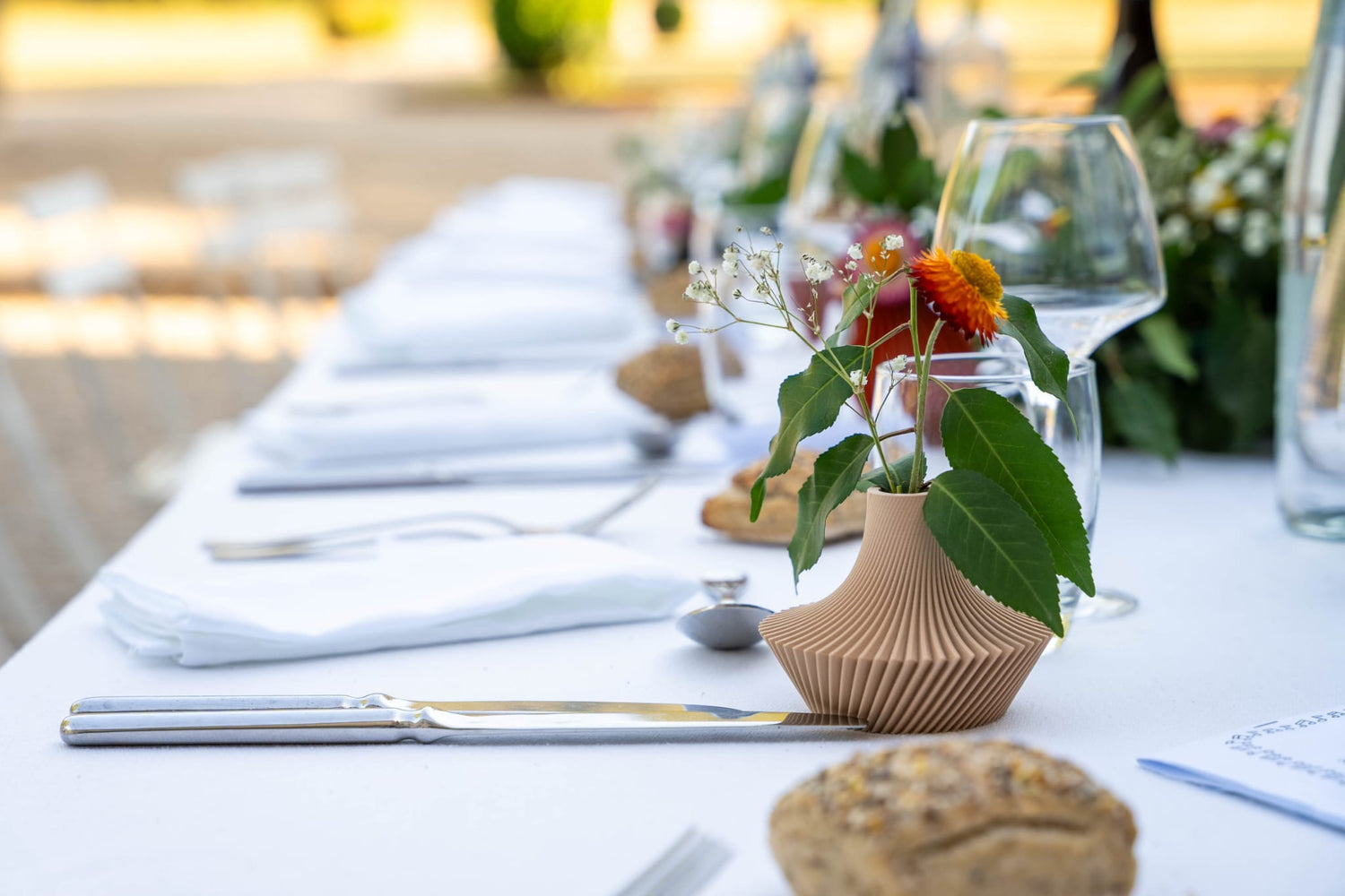 Photo d'un mini vase beige Cysclonia sur une table de mariage