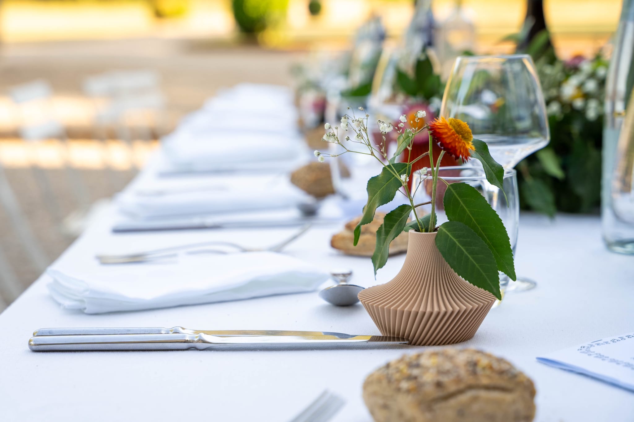 Photo d'un mini vase beige Cysclonia sur une table de mariage
